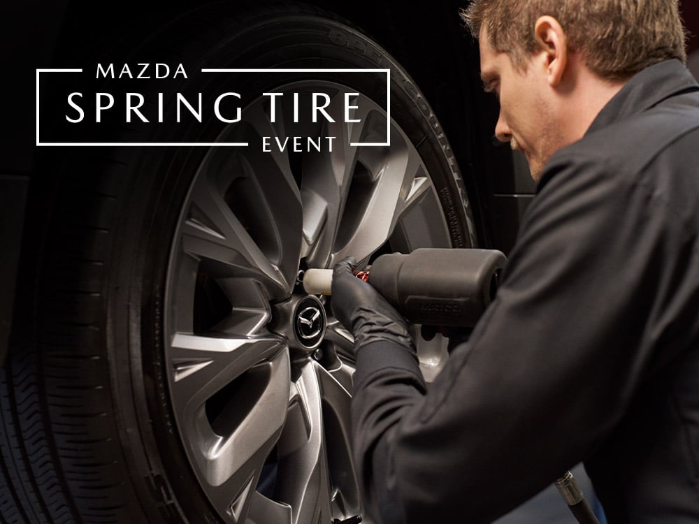 Mazda technician tightening lug nuts on wheel of vehicle