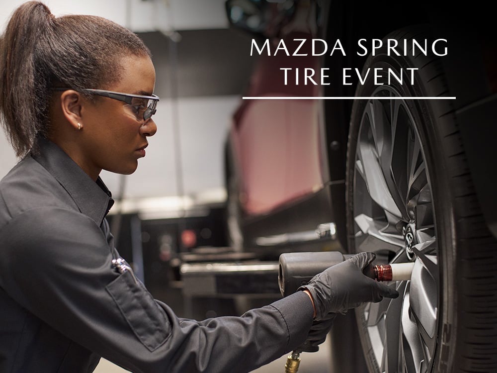 Mazda technician tightening lug nuts on wheel of vehicle