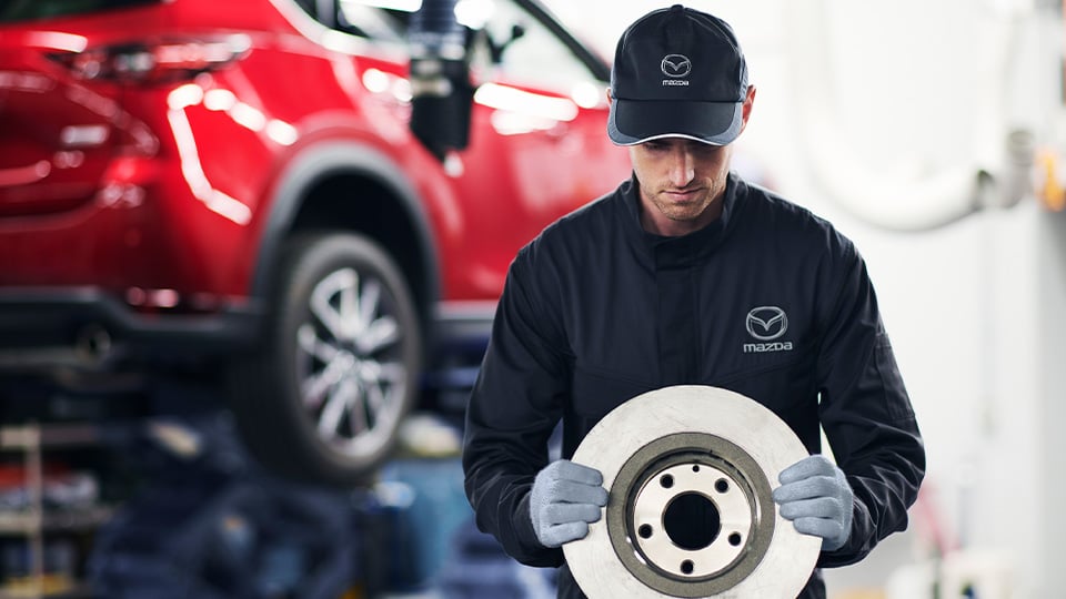 Mazda technician holding a brake rotor