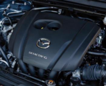 Inside the hood of the CX-30, an engine cover with a Mazda logo badge and Skyactiv G insignia. 