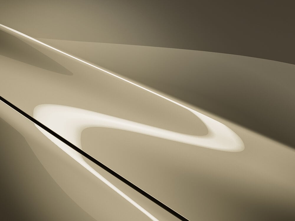 Close up on the hood of a Zircon Sand Metallic CX-5, overhead light reflects accentuating its curves