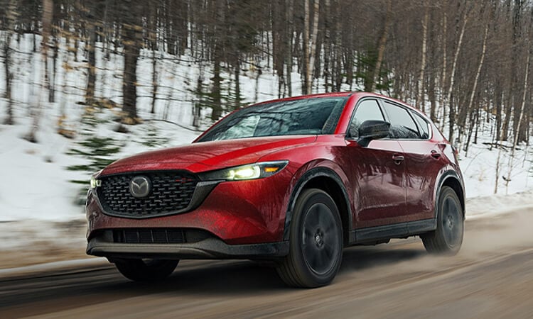 Un CX-5 rouge vibrant cristal métallisé sur une route de campagne hivernale. 