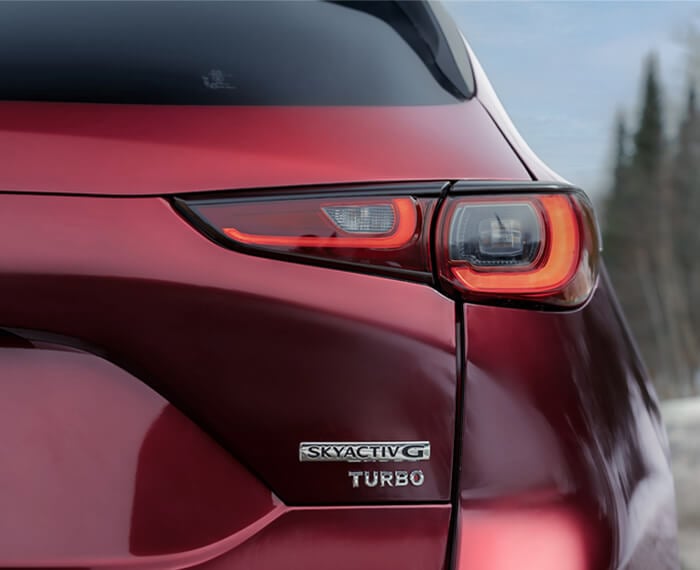 Close up of SkyactivG Turbo badge on rear hatch of Soul Red Crystal Metallic Mazda CX-5. 