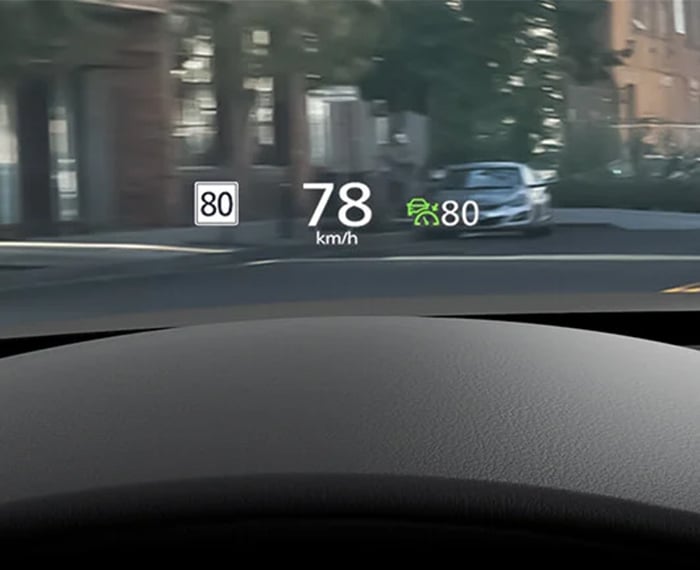 Driving display projected onto interior windshield shows current speed limit and speed. 