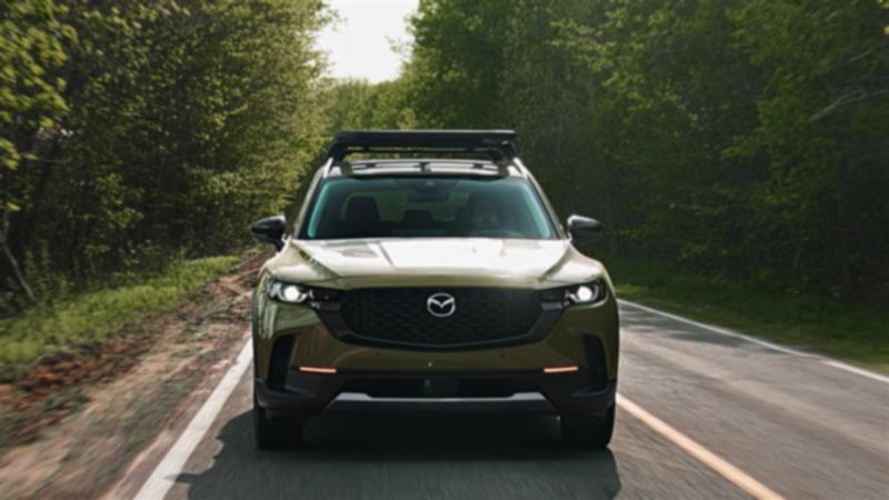 Zircon Sand Metallic CX-50 driving in forest, grill on towards camera POV.