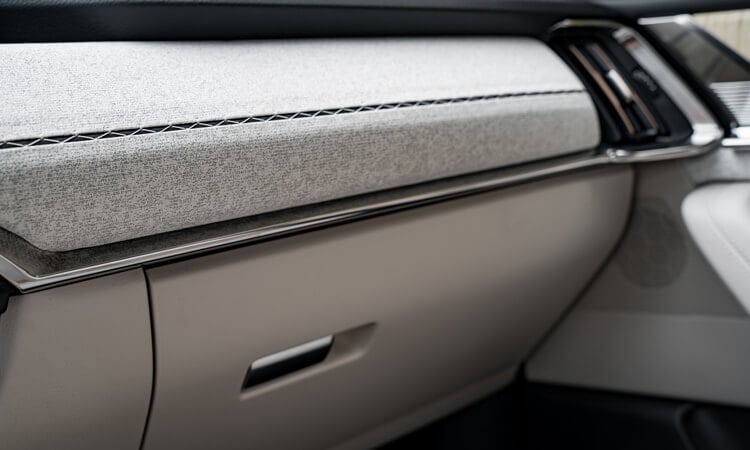 Close up of detail and materials of glove box and dash above.