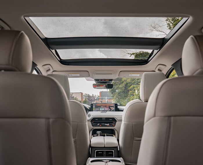  View from behind the third row up the middle of a CX-90 looking up showing the expansive Panoramic Moonroof.