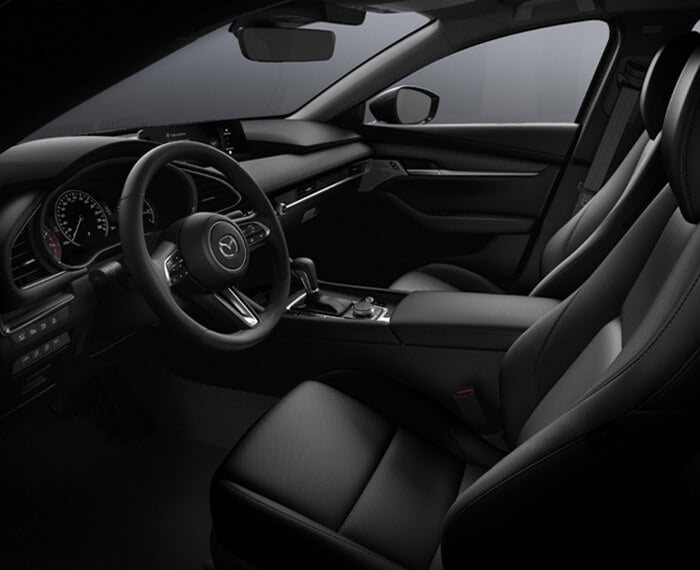 Comfortable front seating in the Mazda3 sedan, driver’s window POV looking across seats. 