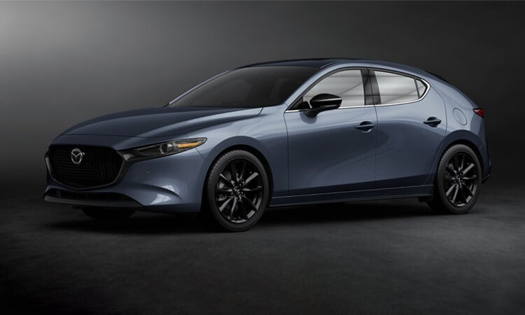 In studio/seamless environment, a Deep Crystal Blue Mica Mazda3 Sport is parked in profile. 