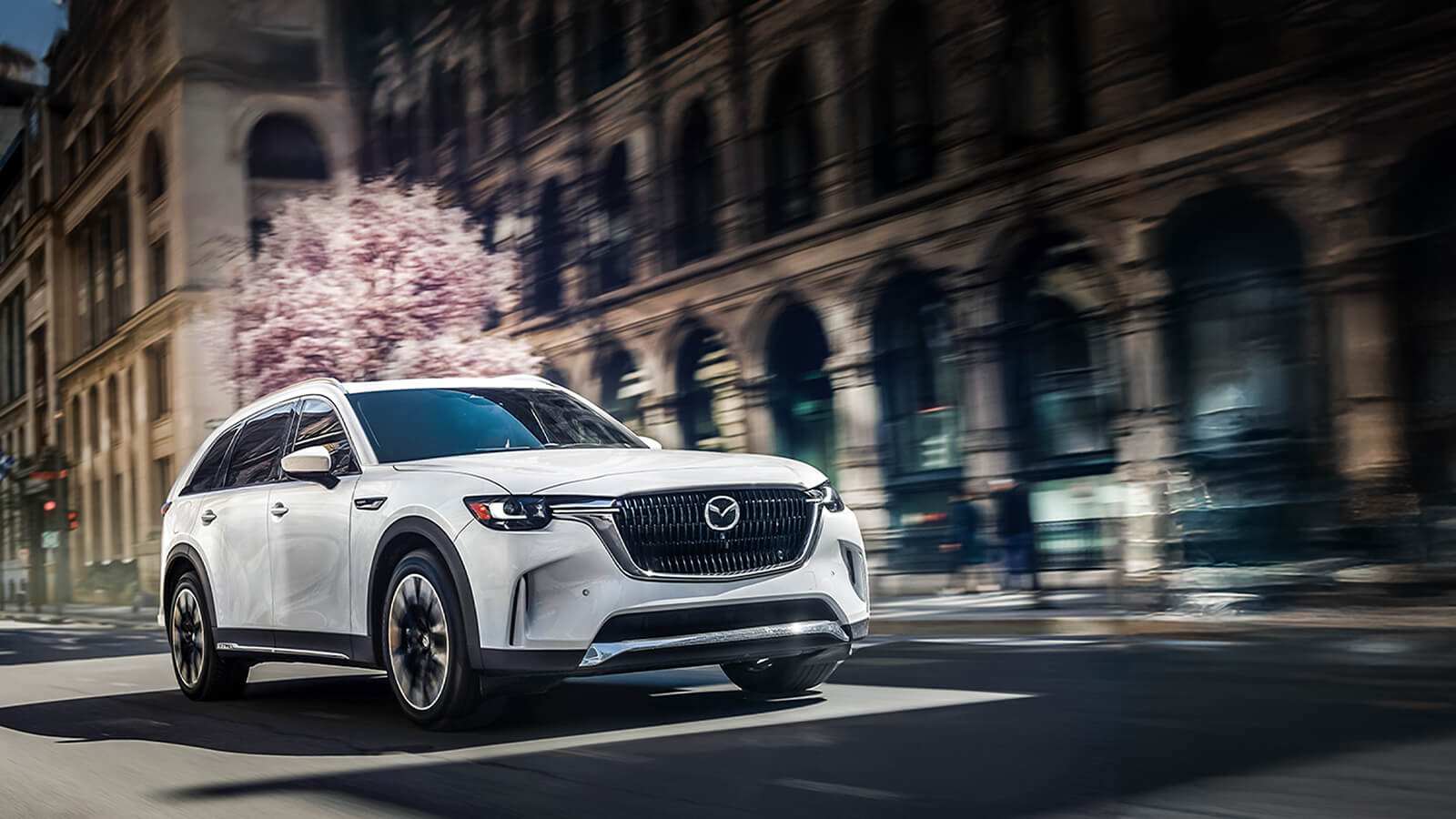 A platinum Mazda3 parked on the street.