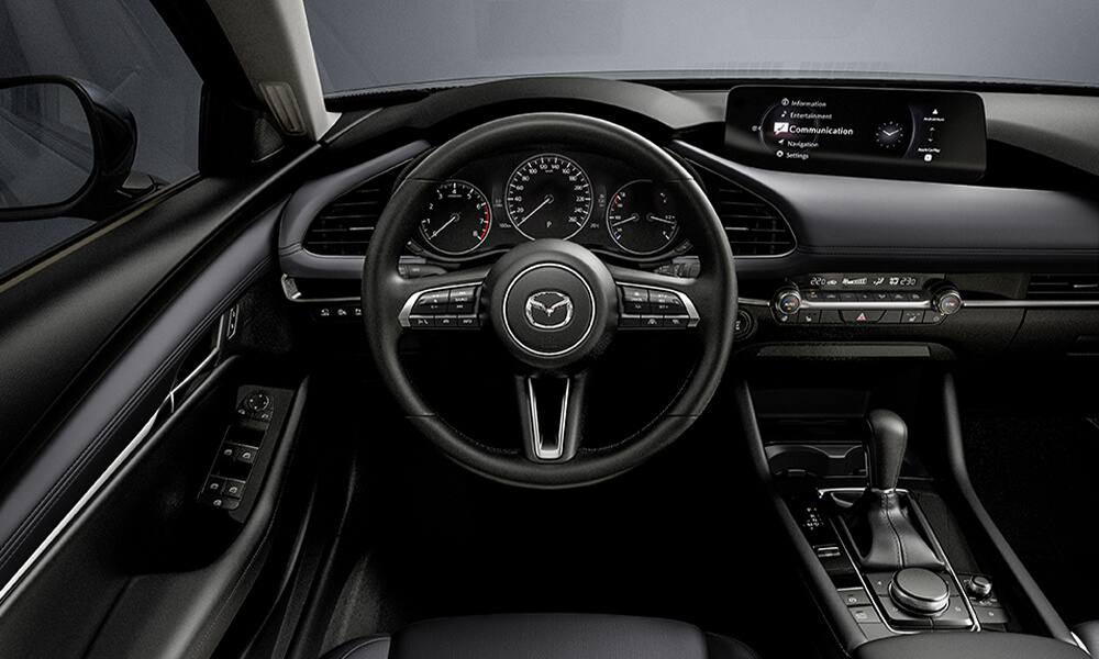 View from the driver’s seat of a Mazda3 Sport, focused on the steering wheel.